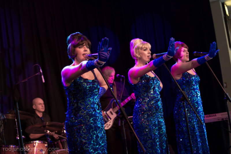 Girls in long blue gowns singing "Stop"